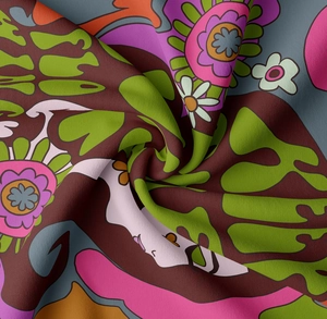 Detailed macro view of psychedelic floral tapestry fabric showing soft twill texture and vibrant colors