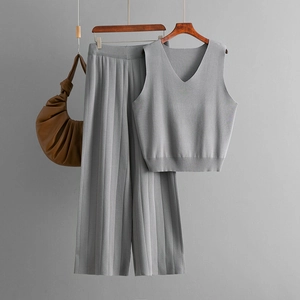 Detail of grey knitted two-piece set featuring a V-neck tank top and pleated wide-leg pants