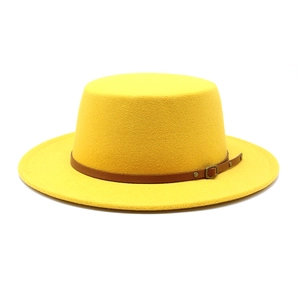 Détail du chapeau canotier jaune avec bande en cuir marron et boucle en métal dorée