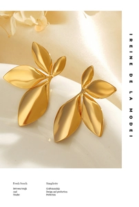 Close-up of golden leaf earrings with a polished finish and elegant floral design