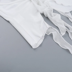 Detail of white ruffled halter top featuring delicate mesh layers and pleated textures