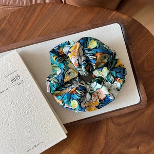 Detail of oil painting floral scrunchie on a wooden tray with a soft aesthetic vibe
