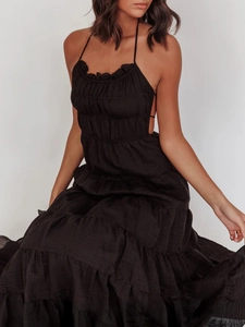 Detail of a black tiered halter dress with pleated texture and layered cake skirt style