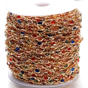 Macro detail of colorful crystal heart charms on a gold DIY chain roll for jewelry