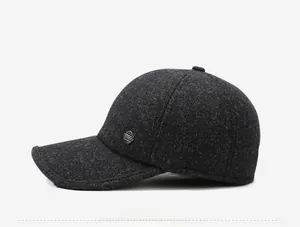 Close-up of a dark grey wool texture baseball cap featuring a round metal fashion badge