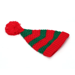 Détail du bonnet de Noël tricoté à rayures rouges et vertes avec pompon et bord côtelé