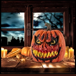 Close-up of a scary orange Halloween pumpkin with sharp teeth on a dark wooden table