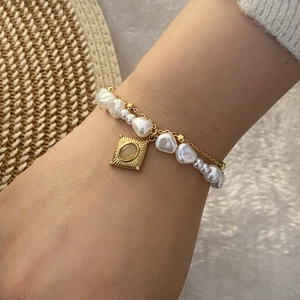 Double-layered gold chain bracelet with irregular pearls and green gemstone square pendant