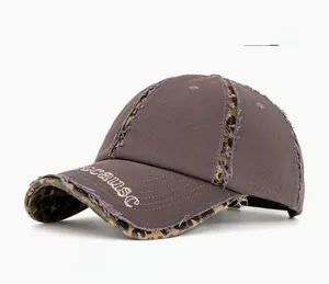 Detailed macro of distressed grey cotton baseball cap with leopard print edges and embroidery