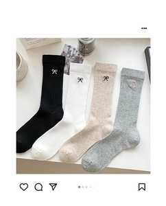 Detailed close-up of ribbed cotton crew socks in four colors with bow embroidery