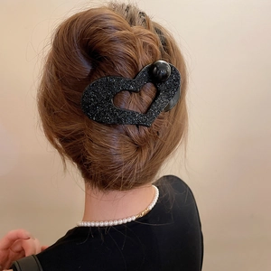 Detailed view of heart-shaped black crystal hair claw clip with large black pearl accent