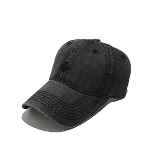 Gros plan d'une casquette en denim gris foncé avec broderie croix noire et coutures rétro