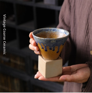 Detail of vintage coarse pottery mug with unique blue-brown flowing glaze finish
