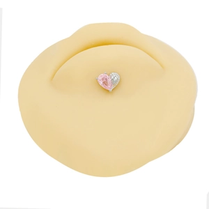Pink heart-shaped zircon belly button ring with silver metal finish on a display mold