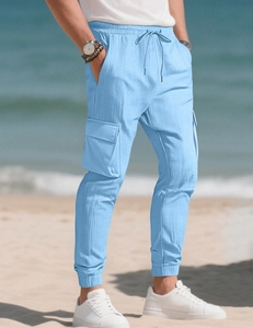 Détail du pantalon cargo bleu ciel avec de grandes poches latérales et cordon de serrage
