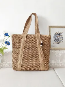 Large woven straw tote bag with tassel charm and twin shoulder straps for beach vacation