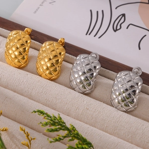 Gold and silver geometric quilted pattern stud earrings on a jewelry display tray