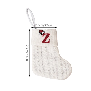 Detail of white knit Christmas stocking with red embroidered letter Z and sizing labels