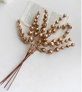 Close-up of sparkling gold sequined berry branches for Christmas tree decoration
