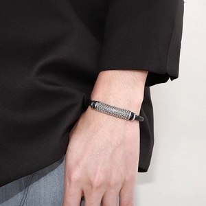 Détail du bracelet en cuir tressé avec chaîne en acier inoxydable sur poignet masculin