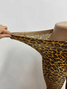 Macro detail showing the extreme stretch and elastic texture of leopard print leggings