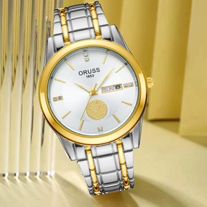 Detailed macro view of dual-tone gold stainless steel watch featuring unique sailboat relief