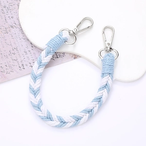 Blue and white woven cotton phone strap with silver lobster clasps on a white tray