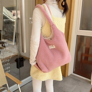 Detail of pink and white plush tote bag showing soft faux lamb wool texture and large capacity