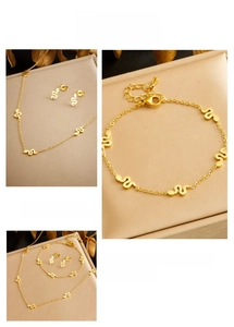 Detail of minimalist gold plated snake-style wave jewelry set on decorative display