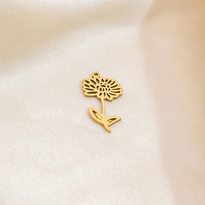 Detailed view of a golden sunflower pendant accessory on a soft beige silk background