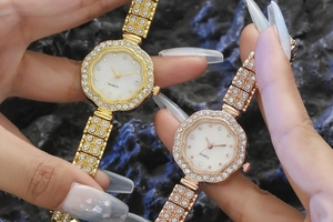 Gros plan de montres à quartz élégantes en forme de fleur, or et or rose, avec strass