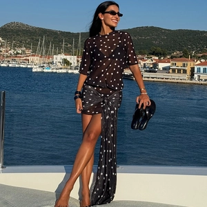 Close-up of stylish black polka dot sheer mesh beach dress and wrap skirt on yacht