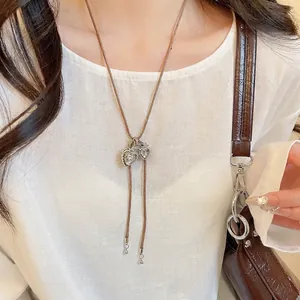 Minimalist silver heart pendant necklace with brown cord shown on a model neck