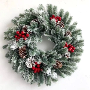 Christmas wreath with LED lights, red berries, pine cones and artificial snow effect