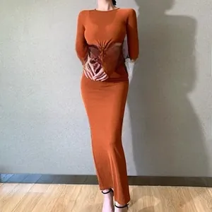 Detail of caramel orange slim fit long sleeve maxi dress with waist cutout design