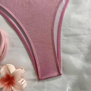 Detailed macro view of pink glitter bikini fabric texture with fine stitching details