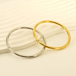 Close-up of minimalist gold and silver stainless steel bangles with hinge details