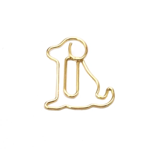 Golden metal paperclip in minimalist dog shape silhouette isolated on white background
