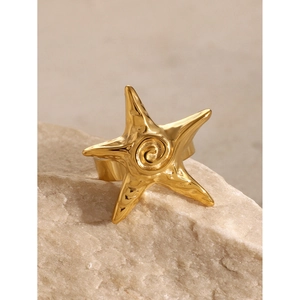 Macro shot of 18k gold plated starfish ring with hammered texture on a natural stone