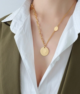 Close-up of asymmetrical chain necklace with gold portrait coin pendant and OT toggle clasp