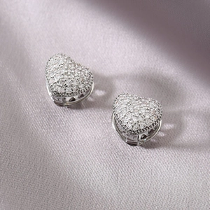 Sparkling silver heart huggie earrings with micro-set cubic zirconia on soft fabric