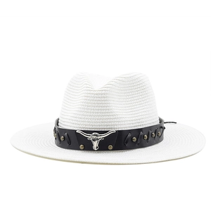 Close-up of white woven cowboy hat with black leather band and silver bull head detail