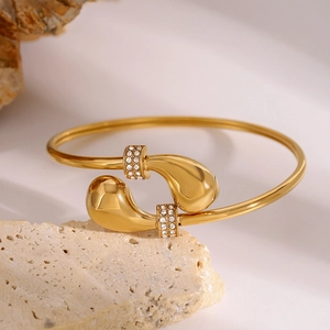 Elegante goudkleurige roestvrijstalen open armband met druppelvorm en zirkonia-accenten