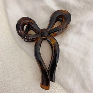 Elegant tortoiseshell resin bow hair claw clip with minimalist brown pattern for women