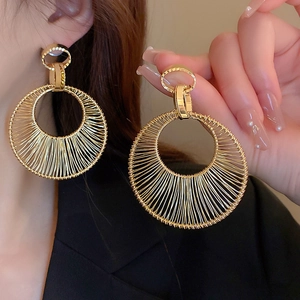 Golden woven mesh hoop earrings in large circular design with bohemian metallic texture