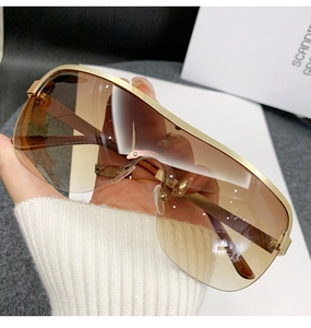 Close-up of golden metal frame sunglasses with gradient brown lenses in soft lighting