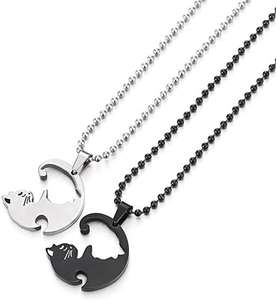 Close-up of yin yang cat pendants in silver and black on bead chains for couples