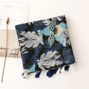 Detail of navy leaf print scarf with tropical patterns and soft fringe tassels