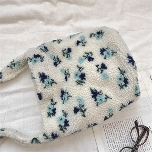 Detailed texture of white lamb wool tote bag featuring a blue floral pattern print