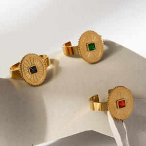 Detailed view of three 18K gold-plated stainless steel sunburst rings with square gemstones